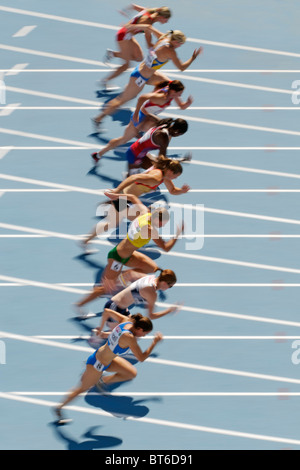 Velocisti femmina in esecuzione su pista blu nella gara femminile Foto Stock