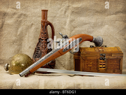 Still-life con una pistola, bottiglia, rapier e tronco Foto Stock