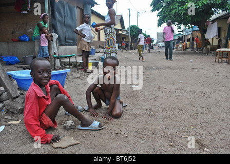 Bambini giocano su una strada fangosa in Treicheville, Abidjan, Costa d'Avorio, Africa occidentale Foto Stock