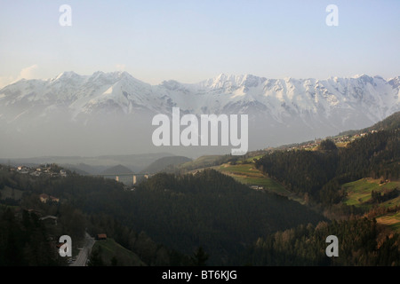 Le Alpi vicino a Ponte Europa in Austria. Il ponte può essere visto in lontananza. Foto Stock