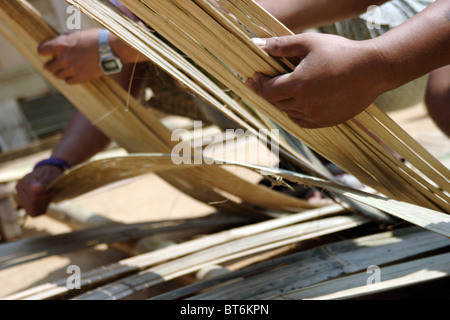 Karen Paduang rifugiati provenienti dalla Birmania (Myanmar) sono la realizzazione di un tetto di paglia in Ban Nai Soi, Thailandia. Foto Stock