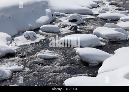 Coperte di neve pietre nel fiume Trisanna, Paznautal Valley, Paznaun in Tirolo, Austria Foto Stock
