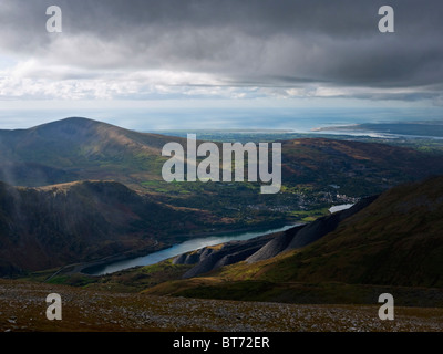 Llanberis, accoccolato tra Eilio Moel e Llyn Peris in Snowdonia. Il bottino dei cumuli di Dinorwig cave di ardesia sono visibili. Foto Stock