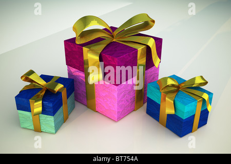 Tre colorate scatole regalo con nastri d'oro, su di una superficie bianca Foto Stock