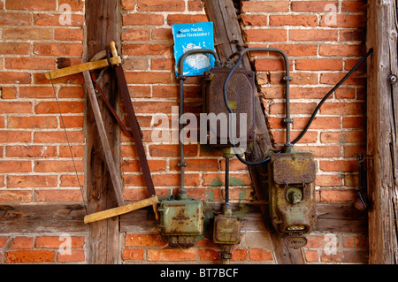 Vecchia scatola di connessione e un handsaw su un di legno a parete, Neso, Mecklenburg Western-Pomerania, Germania, Europa Foto Stock