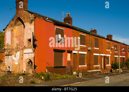 Una fila di terrazzamenti abbandonati alloggiamento in attesa di demolizione in Clayton distretto di Manchester, Inghilterra, Regno Unito Foto Stock