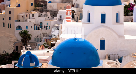 Tipica architettura con cupole della chiesa e torre campanaria Oia Santorini Cicladi Grecia Foto Stock