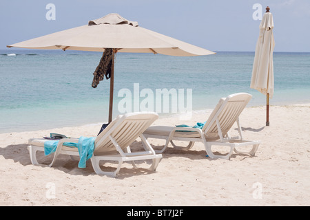 Sdraio e ombrellone sulla spiaggia pubblica di Flic en Flac a ovest dell'isola tropicale di Mauritius. Foto Stock