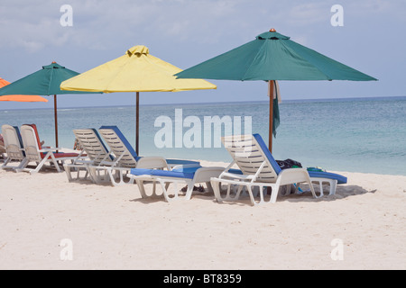 Sdraio e ombrellone sulla spiaggia pubblica di Flic en Flac a ovest dell'isola tropicale di Mauritius. Foto Stock