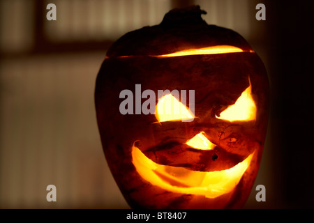 Illuminato rapa halloween jack-o-lantern al di fuori della finestra di una casa per allontanare gli spiriti maligni. Foto Stock