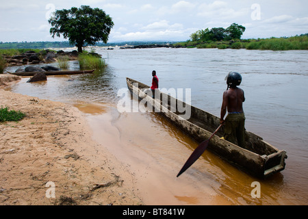 Due uomini galleggiante in una barca di legno sul fiume Congo Foto Stock