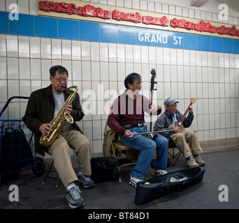 Senior cinese uomini suonare strumenti musicali tradizionali a Grand Street Subway Station in Chinatown New York City USA Foto Stock