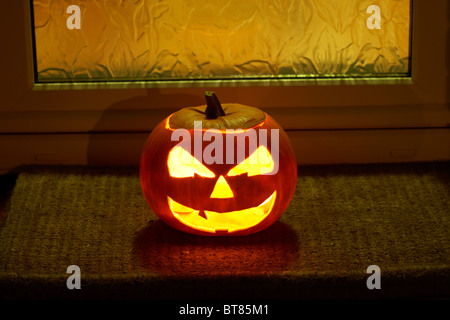 Illuminata la zucca di halloween jack-o-lantern al di fuori di una casa per allontanare gli spiriti maligni Foto Stock