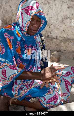 Jambiani, Zanzibar, Tanzania. Donna che fa la corda da cocco, buccia di cocco fibra. Foto Stock