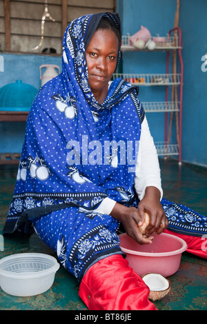 Jambiani, Zanzibar, Tanzania. Donna che fa il latte di cocco. Indossa un naso-pin nella sua narice sinistra. Foto Stock