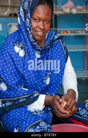 Jambiani, Zanzibar, Tanzania. Donna che fa il latte di cocco. Indossa un naso-pin nella sua narice sinistra. Foto Stock