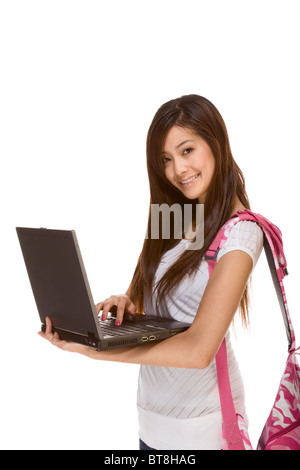 Gentile Asian High School girl studente in piedi in jeans con zaino e tenendo i notebook e composizione prenota Foto Stock