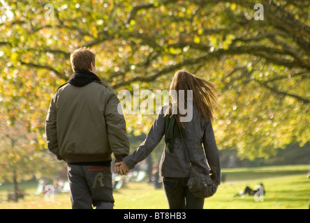 Un ragazzo e una ragazza giovane coppia passeggiate nel parco in autunno Foto Stock