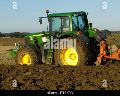 John Deere trattore 6930 arando un campo su una luminosa e soleggiata giornata di ottobre Foto Stock