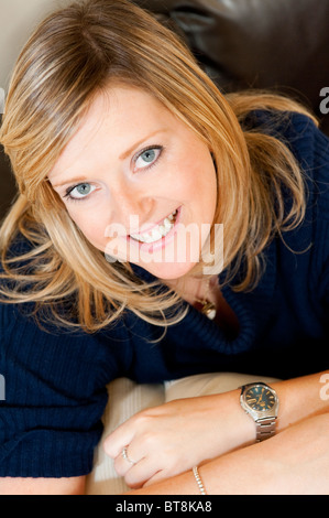 Close up ritratto di una giovane donna che guarda verso l'alto sorridente e cercando felice. Foto Stock