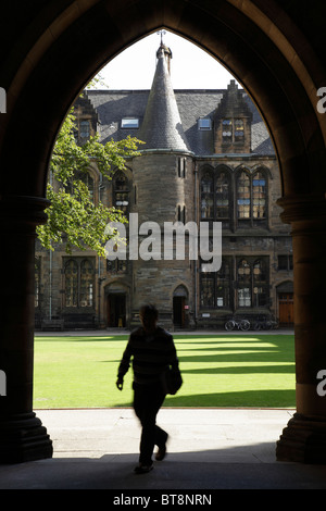Lo studente universitario ha visto attraverso un arco che conduce al Quadrangle orientale presso il campus dell'Università di Glasgow, Gilmorehill, Glasgow, Scozia, Regno Unito Foto Stock