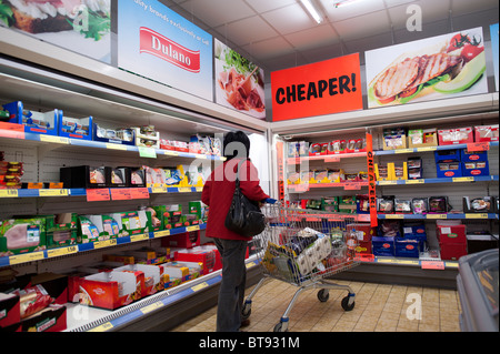 Una donna shopping affare per alimenti in sconto Lidl Supermercato UK Foto Stock