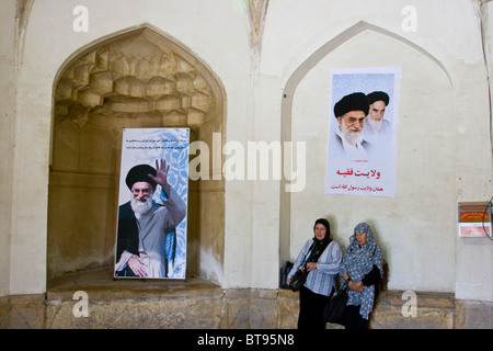 I turisti nella parte anteriore del poster di Khameini all'Arg in Shiraz Iran Foto Stock