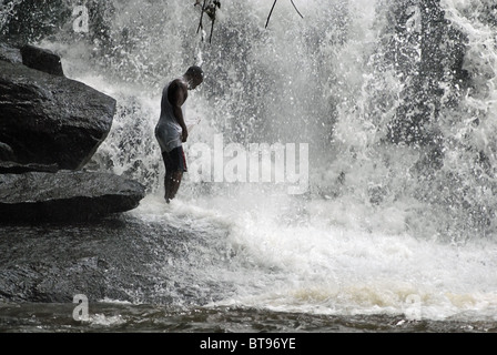 L'uomo la balneazione in 'Cascades de Man' cascata vicino all uomo, Costa d Avorio, Africa occidentale Foto Stock