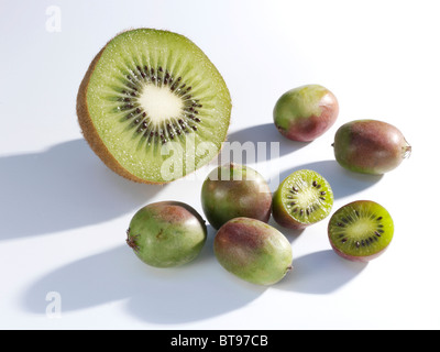 Kiwi e mini-kiwi tagliati a metà e intera Foto Stock
