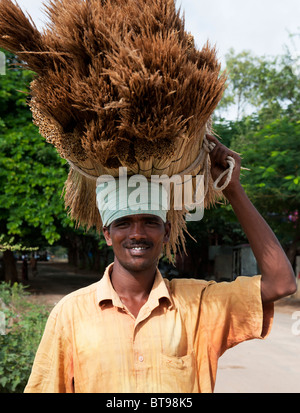 Indian uomo vendere spazzole artigianali che sono in equilibrio sulla sua testa. Andhra Pradesh, India Foto Stock