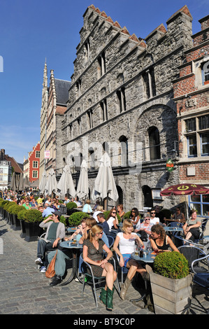 I turisti alla caffetteria sul marciapiede in banchina lungo il fiume Lys alla Graslei / Erba Lane a Gand, Belgio Foto Stock