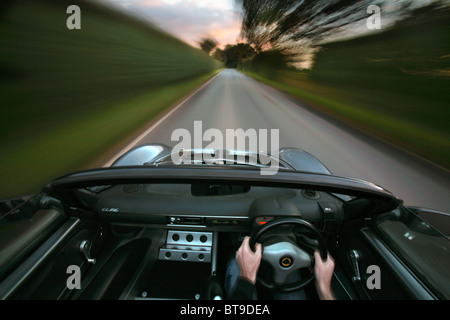 Una Lotus Elise auto sportiva azionato a velocità lungo una strada di campagna Foto Stock