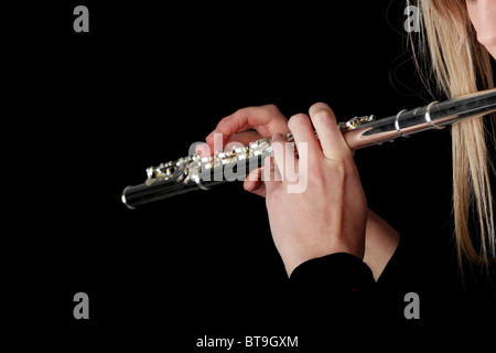 Ritratto di una donna la riproduzione di flauto traverso, isolato su nero Foto Stock