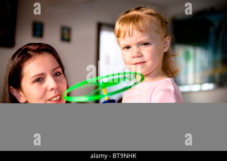 La Madre che mostra a sua figlia come utilizzare un nuovo giocattolo Foto Stock