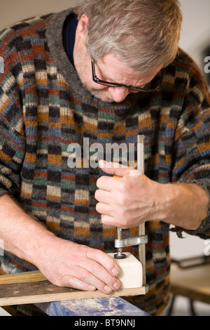 Uomo che fa un giocattolo di legno carrello. Foto Stock