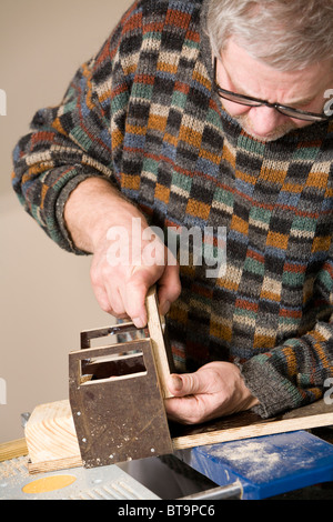 Uomo che fa un giocattolo di legno carrello. Foto Stock