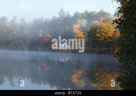 La riflessione di traffico sul percorso 16 in Chocorua Lago in Tamworth, New Hampshire USA durante i mesi di autunno in condizioni di velatura Foto Stock