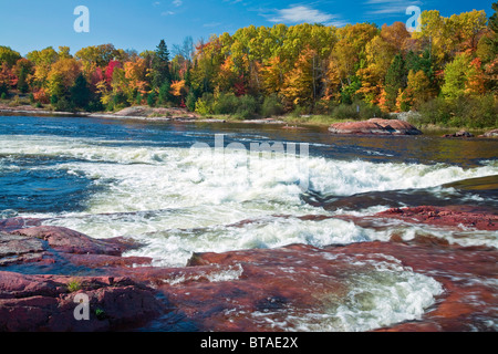 Alberi colorati e rocce al fiume Mississagi e rapide in autunno vicino al fiume cieco sull'autostrada #17 in Ontario, Canada Foto Stock
