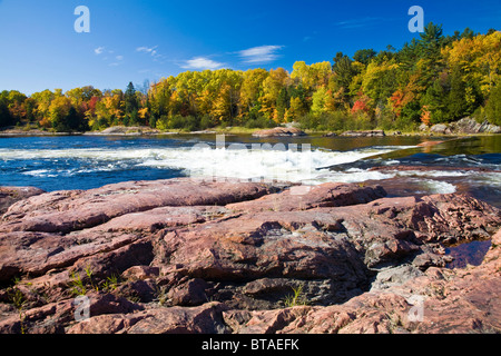 Alberi colorati e rocce al fiume Mississagi e rapide in autunno vicino al fiume cieco sull'autostrada #17 in Ontario, Canada Foto Stock