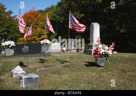 Sbiadita Amerianc bandiere al vento a lato sud cimitero di Nottingham, New Hampshire Foto Stock