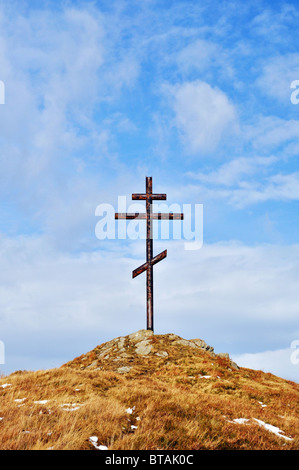 Croce contro il cielo sulla collina alta realizzata in metallo Foto Stock