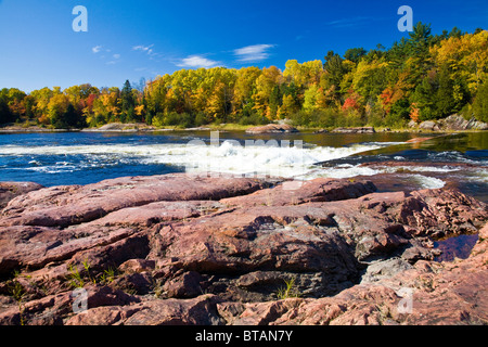 Alberi colorati e rocce al fiume Mississagi e rapide in autunno vicino al fiume cieco sull'autostrada #17 in Ontario, Canada Foto Stock