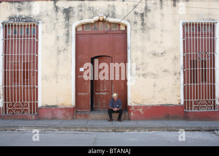 TRINIDAD: uomo cubano seduto in porta Foto Stock