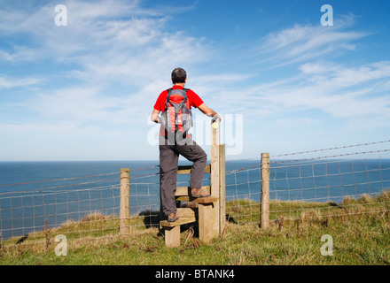 Escursionista maschio sul modo di Cleveland national trail tra Skinningrove e Staithes, North Yorkshire, Inghilterra, Foto Stock