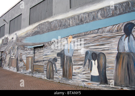 L'Islanda, la penisola di Reykjanes, Keflavik. Dipinto murale di salare pesce lavorazione sul centro di edificio. Foto Stock