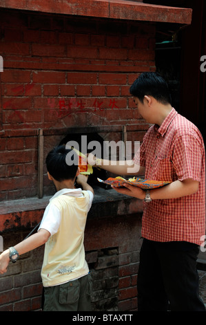 Peccato Sze Si Ya Cinese Tempio Taoista Chinatown Kuala Lumpur in Malesia uomo burning joss carta denaro fantasma tradizionali divinità cinese Foto Stock