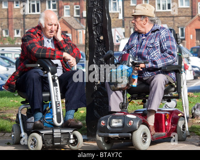 Due uomini anziani su Motability scooter Foto Stock