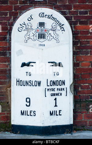 Vecchia pietra miliare circa 1911, visto in Kensington dando la distanza di Hounslow e Hyde Park Corner. Londra. Regno Unito Foto Stock