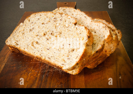 Ampie fette di pane con grani misti in legno scheda di pane Foto Stock