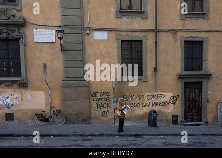 Graffiti politici spruzzata tramite aerosol su edificio pubblico vicino al Ponte Vecchio a Firenze. Foto Stock